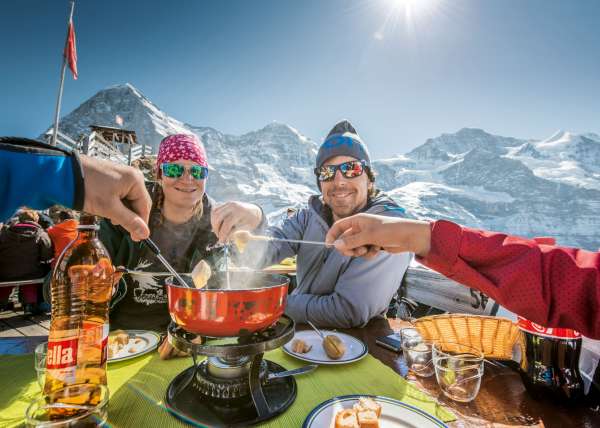 A close-up shot of a tobogganer's face, beaming with joy, with the Eiger North Face blurred in the background. This shows the excitement of tobogganing with the iconic Eiger in view.