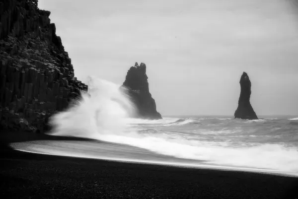 Reynisfjara Black Sand Beach, Iceland, showing black sand, basalt columns, and the Reynisdrangar sea stacks.