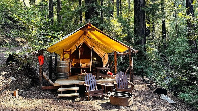 A luxury glamping tent perched on a cliff overlooking the ocean in Big Sur. The tent is spacious and well-appointed, with comfortable furniture and panoramic views, demonstrating glamping near Big Sur Coast.