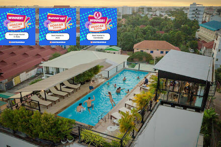 A bustling Siem Reap street scene with tuk-tuks and vendors.