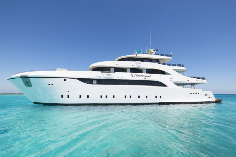 A luxury yacht sailing through calm, turquoise waters