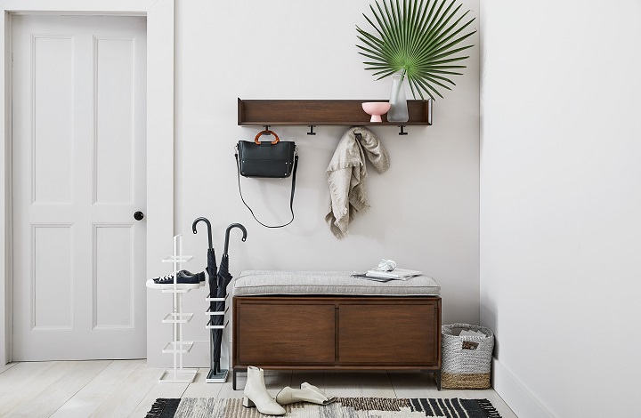 A simple wooden bench with built-in storage underneath filled with neatly arranged shoes, providing a functional and aesthetically pleasing storage solution for the mudroom.