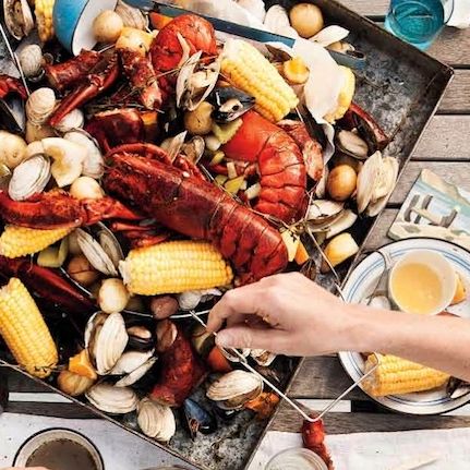 Bass Harbor Head Light standing tall on a dramatic cliff with waves crashing against the rocks, showcasing the rugged coastline of Acadia National Park