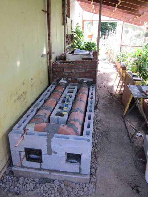 A rocket mass heater's internal construction, highlighting the insulated heat riser.