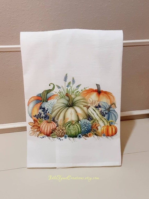 A bright and welcoming farmhouse kitchen decorated for fall with pumpkins, gourds, and burlap accents.