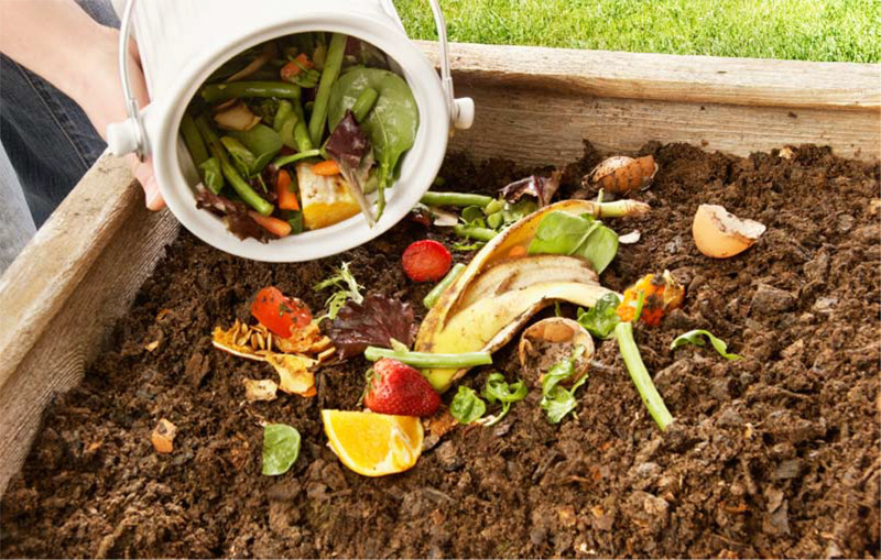 person misting vermicomposting bin