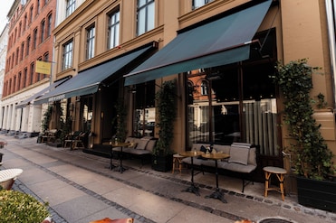 Hotel Sanders Rooftop Terrace - Featuring minimalist design with comfortable teak seating, providing panoramic views of Copenhagen's skyline and perfect for sunset photography.