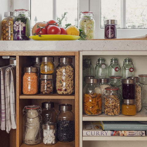 A variety of dry goods stored in airtight glass containers in a pantry