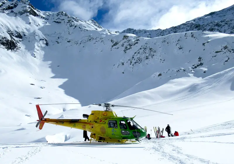 Helicopter landing on a snow-covered peak of The Remarkables