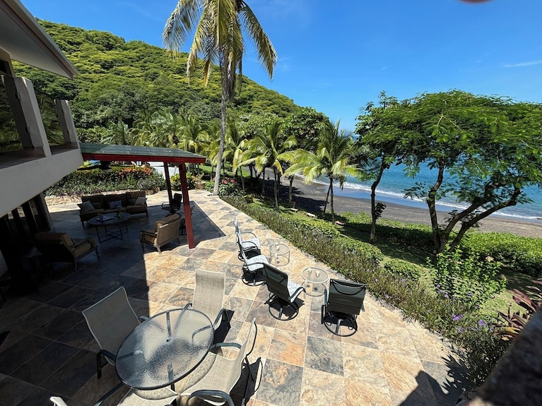 A luxury beachfront villa with a private pool overlooking a serene beach, epitomizing an exclusive and relaxing vacation experience.