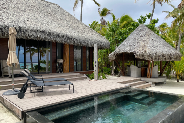 Aerial view of The Brando resort on Tetiaroa, showcasing its villas blending with the natural environment and the surrounding turquoise lagoon.