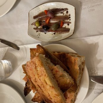 Interior shot of Kabul Hostel, highlighting the use of recycled materials in the decor and the refillable water station. Focus on the textures and colors of the recycled materials, and the clean, modern design of the space.