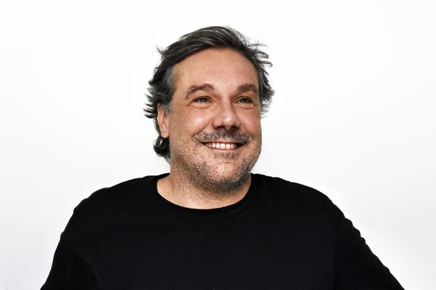 A photograph featuring a person looking at a computer screen with a worried expression. The lighting is soft, creating a sense of anxiety and concern about the future of gaming.