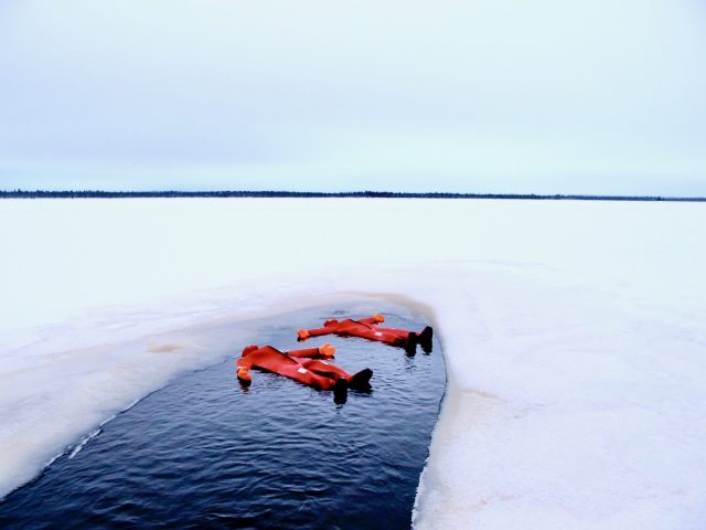 Arctic Sauna Rafting on the Kemijoki River: A wood-fired sauna on a raft floats down a snow-lined river, contrasting warmth and cold with the vast Arctic landscape.