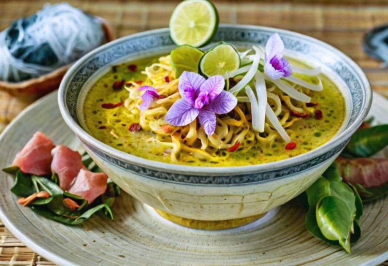 Teenager dancing near Angkor Thom with vegan noodles