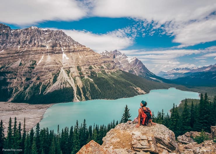 A serene turquoise lake surrounded by snow-capped mountains and evergreen forests in the Canadian Rockies. This image highlights the natural beauty and tranquility of the region, attracting travelers seeking a peaceful mountain getaway.