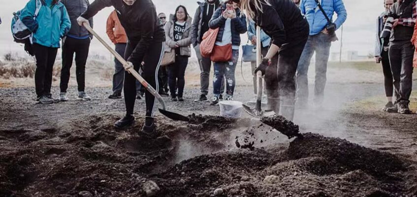 Blake taking a selfie inside the ice cave with a forced smile, looking visibly freezing.