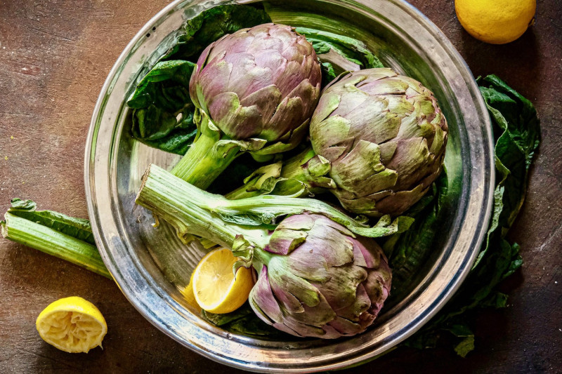 A close-up of a Roman-style artichoke, highlighting its crispy, flower-like appearance.
